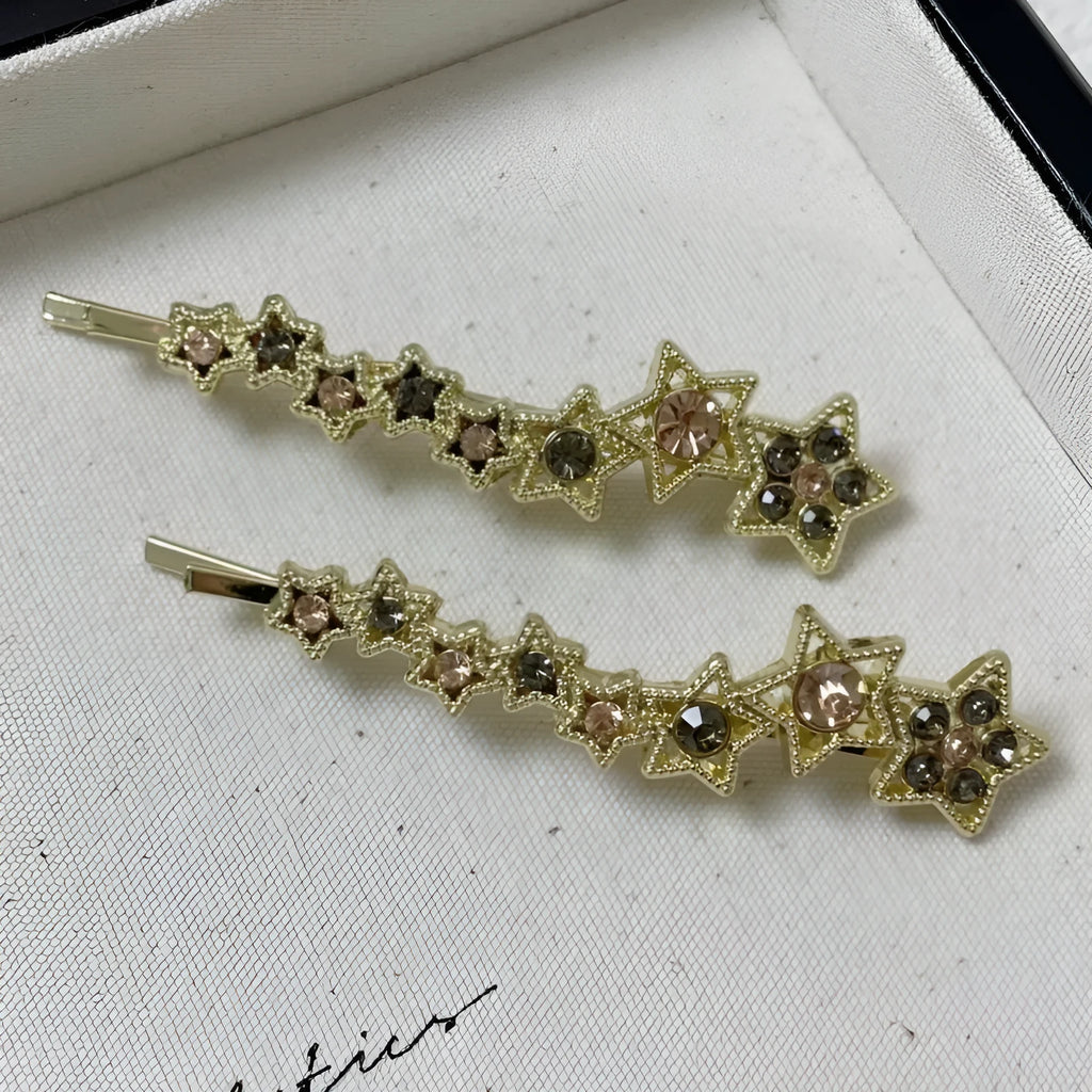 Gold metal hair barrette with a star charm and side clip for bangs.