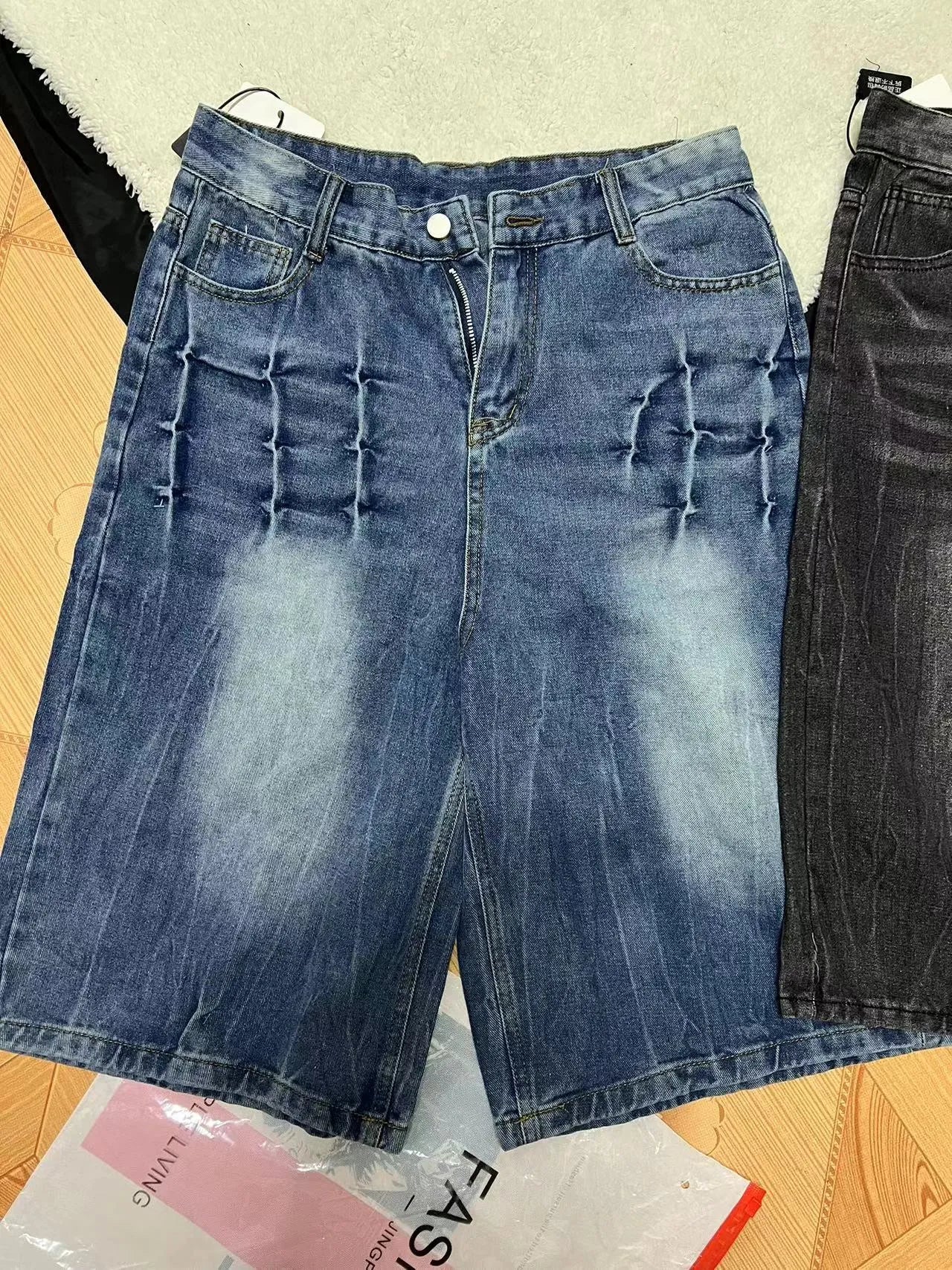 Man wearing loose light blue washed denim cowboy shorts with a straight-leg cut.