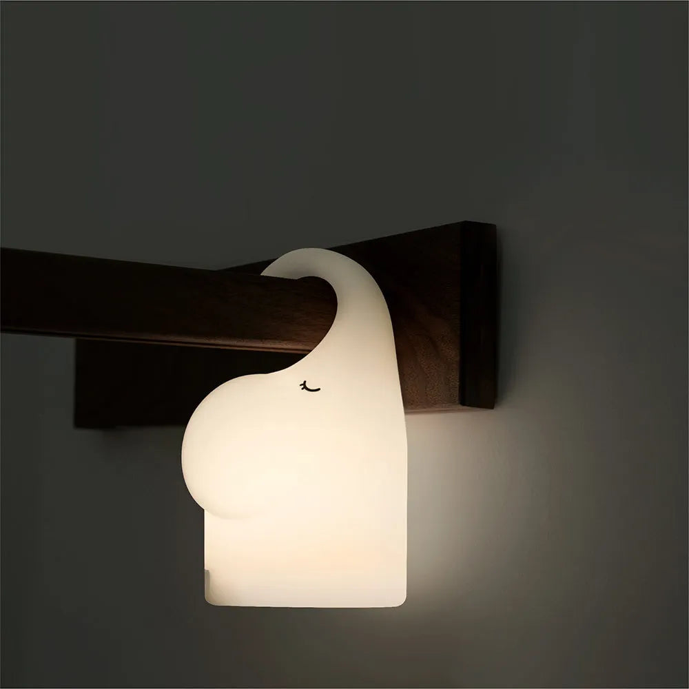 Elephant-shaped silicone night light with warm white LED glow, measuring 96mm wide by 151mm high