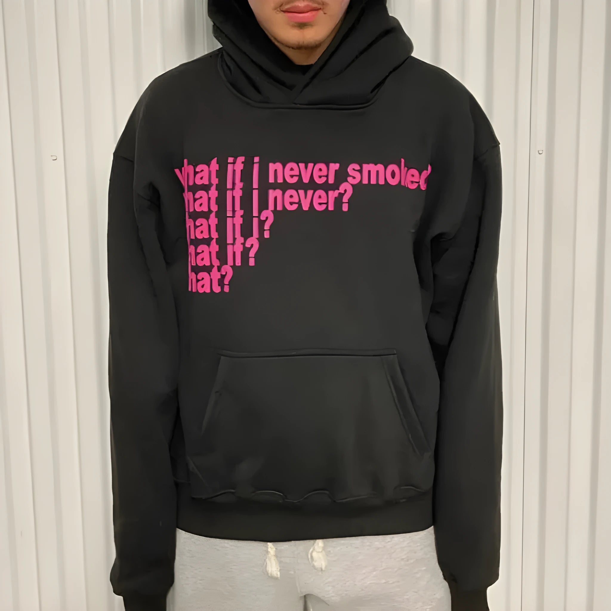 Man's black hooded sweater with a white letter print design on the front.