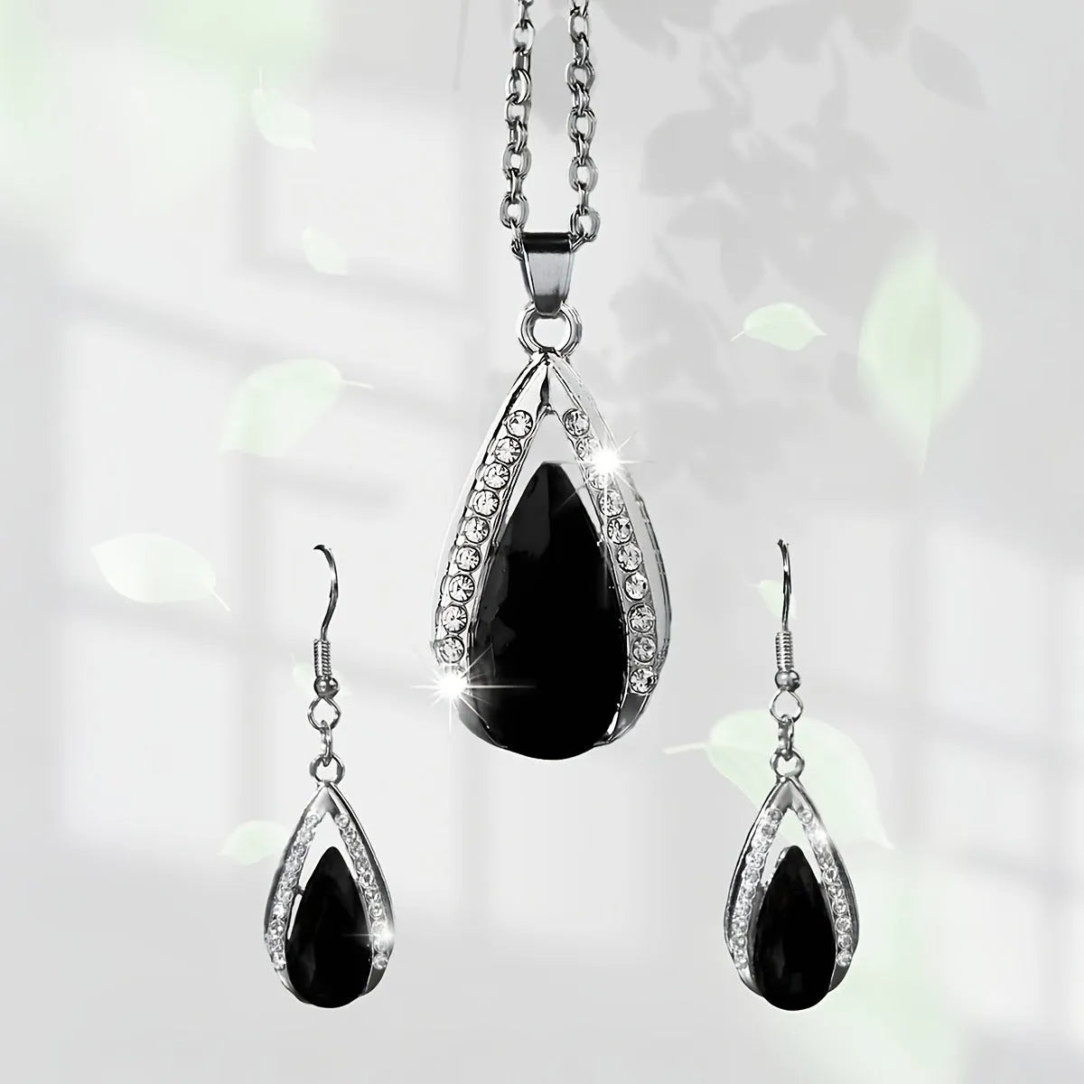 Black and red teardrop glass pendant necklace with matching earrings set on display