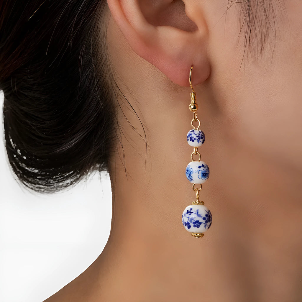 Long blue and white porcelain ceramic bead retro geometric earrings with alloy electroplated frame.