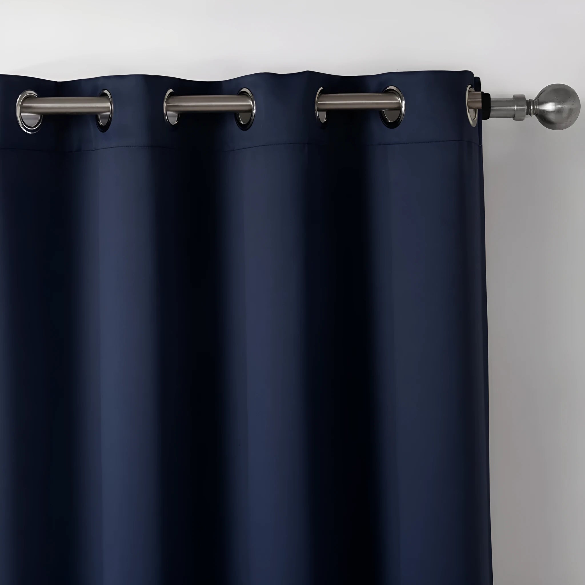 Navy blue blackout curtains with shading cloth fabric in vertical design, showing printed surface and perforated top for hanging