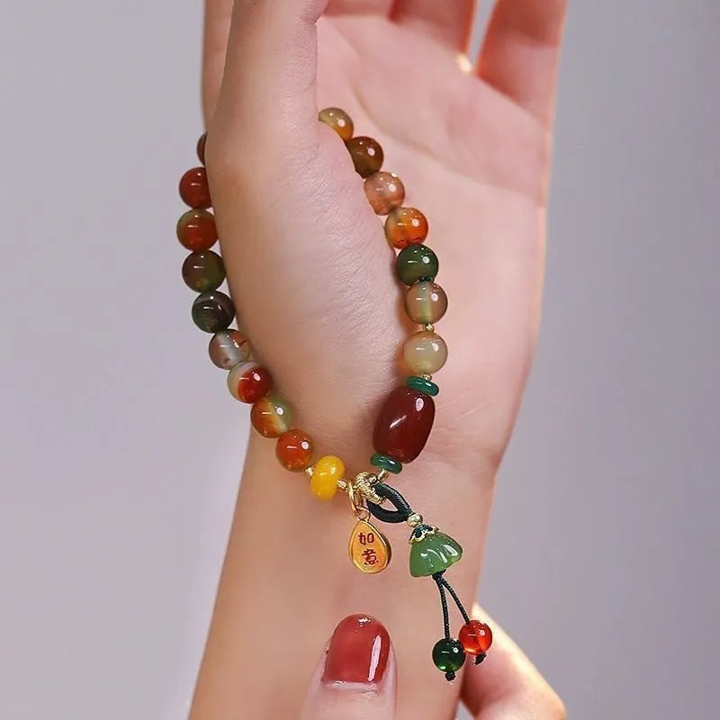 Handmade adjustable bracelet with a detailed lotus charm on a mixed material band.