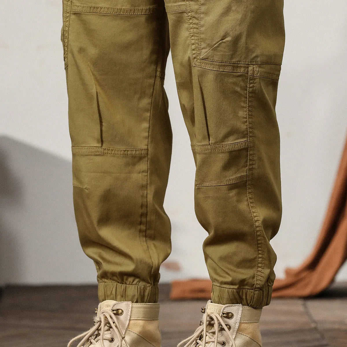 Men's khaki harem pants with tapered legs and ankle bands, made from non-iron cotton fabric.