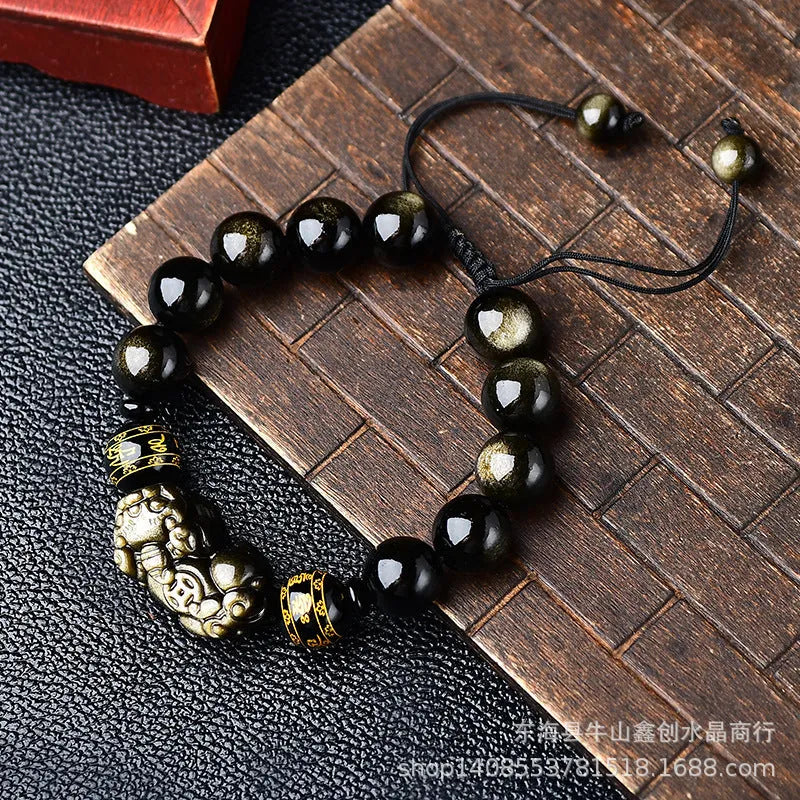 Hand-woven Golden Obsidian Pi Xiu bracelet with animal charm on wrist, showing bead detail.