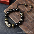 Hand-woven Golden Obsidian Pi Xiu bracelet with animal charm on wrist, showing bead detail.