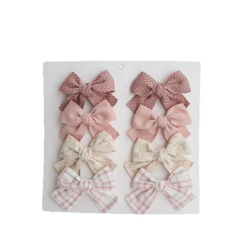 Children's dovetail bow hairclips in cloth, showing colour options like beige brown grid dots and blue flowers.