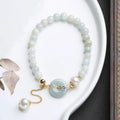 Handcrafted jade pearl bracelet with adjustable peace buckle closure and geometric design elements