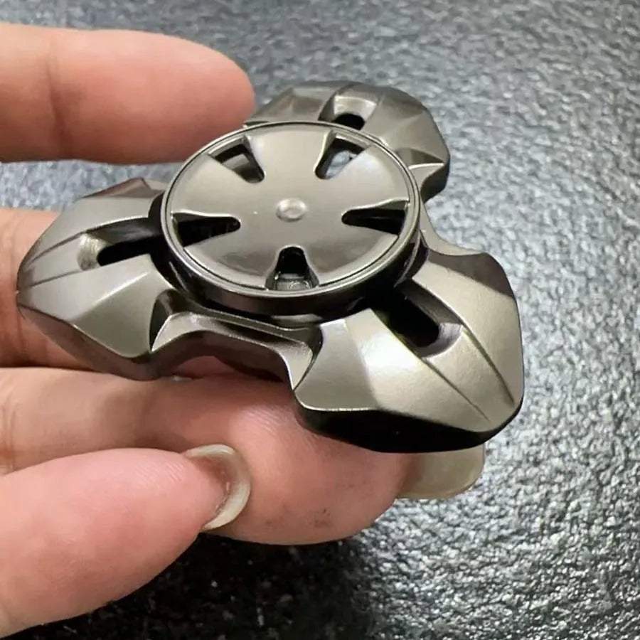 Alloy metal decompression rotating fingertip gyro toy in gun colour and colourful options on a solid background.