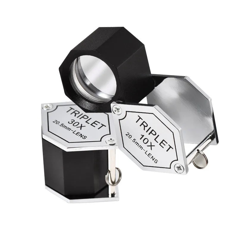 Handheld metal and optical glass magnifying loupe for jewellery and coin inspection.