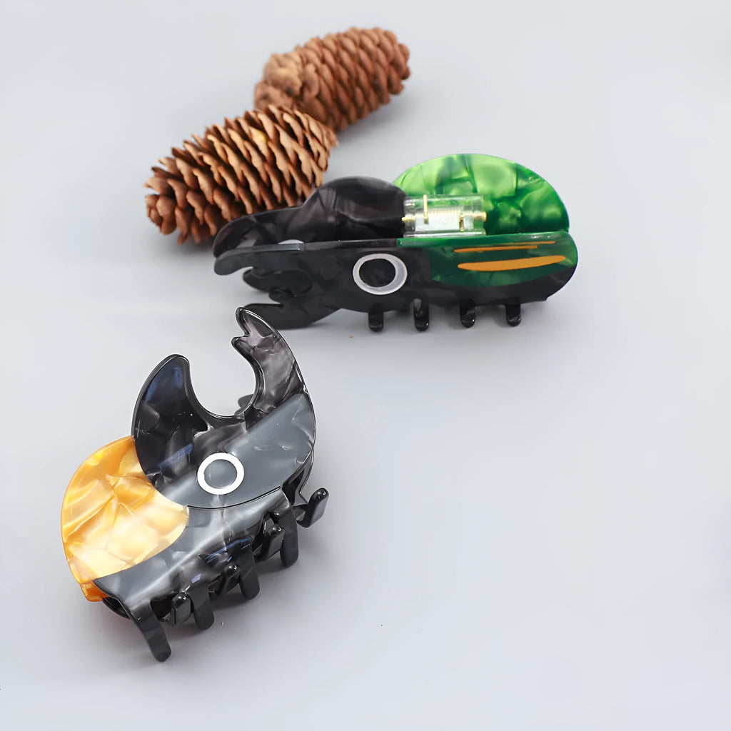 Handmade cartoon insect design hair grip in green beetle, orange beetle, or white caterpillar colour on cellulose acetate.