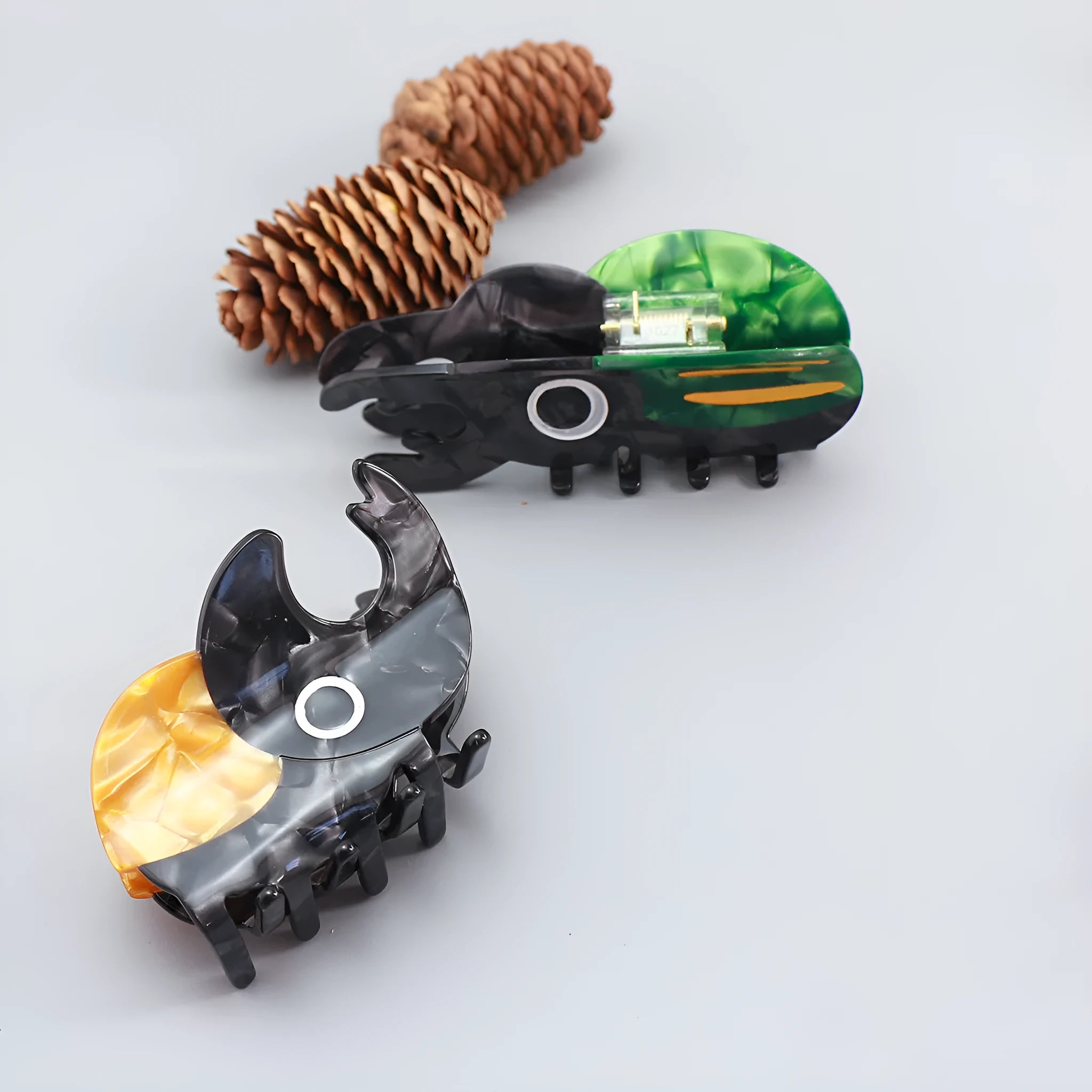 Handmade cartoon insect design hair grip in green beetle, orange beetle, or white caterpillar colour on cellulose acetate.