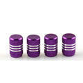 Set of coloured aluminium alloy car tyre valve caps with stainless steel cores on a grey background.