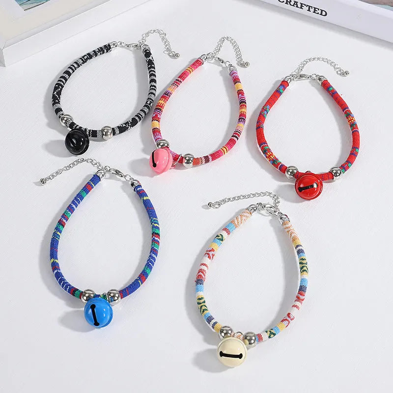 Adjustable dog collar with ethnic patterns and bell in black, blue, pink, red, or white colours, sizes S and L