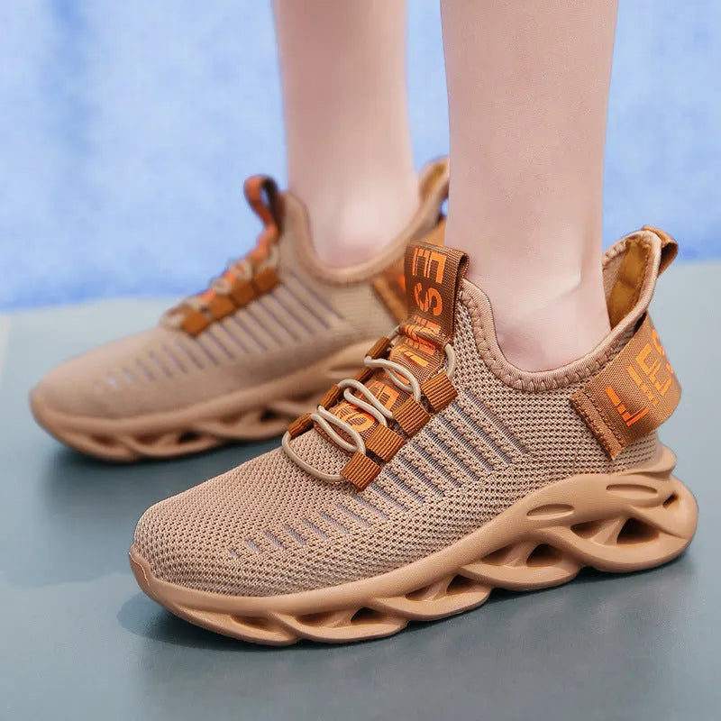 Children's black Velcro sneakers with fabric uppers and EVA soles on wooden floor