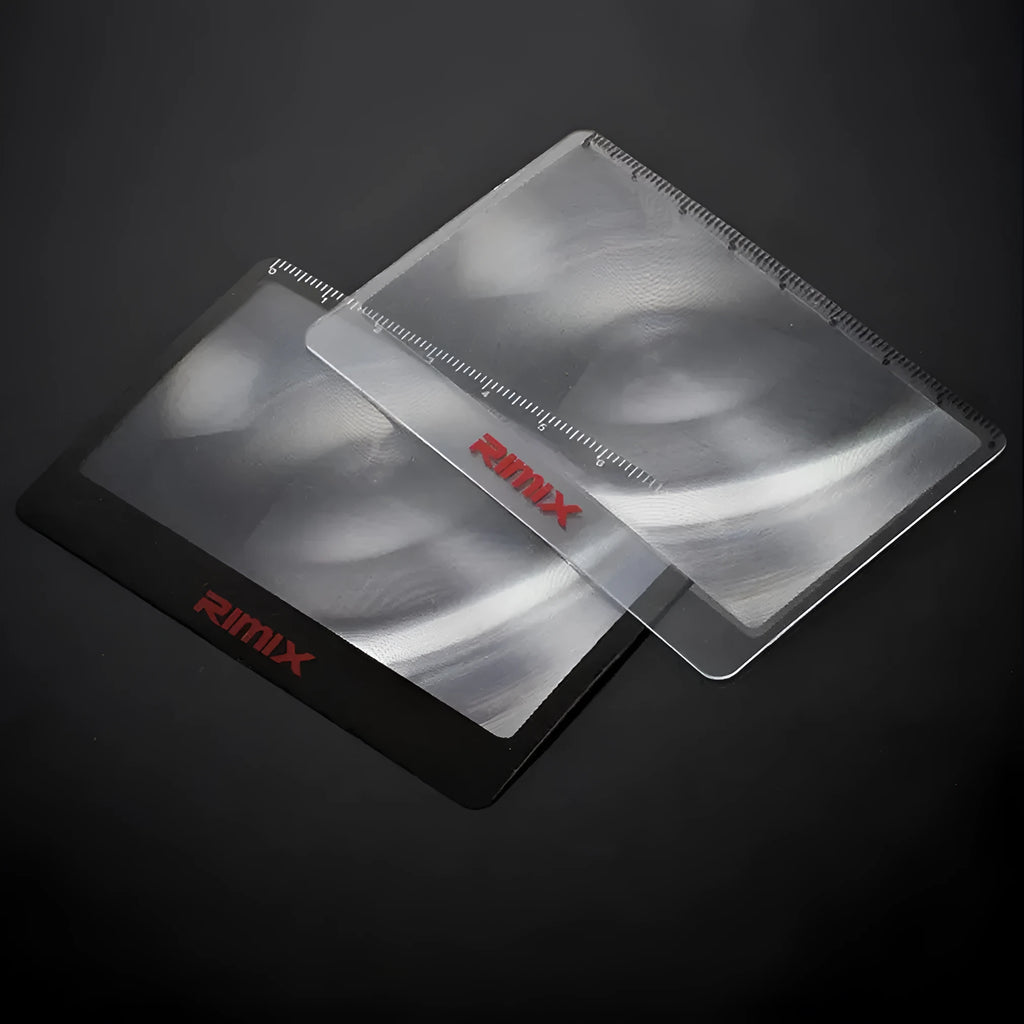 A black and white portable credit card sized plastic magnifier with 6x magnification for outdoor use.