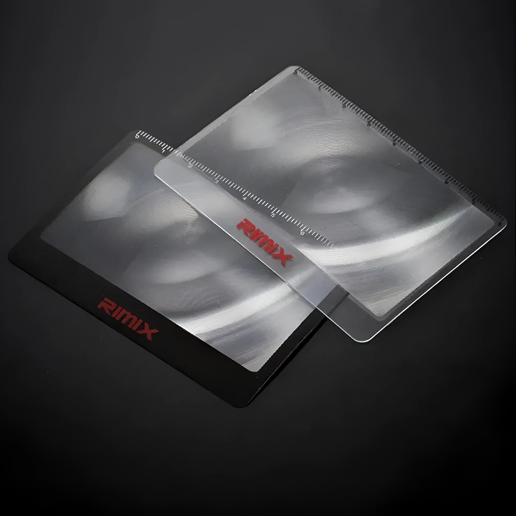 A black and white portable credit card sized plastic magnifier with 6x magnification for outdoor use.