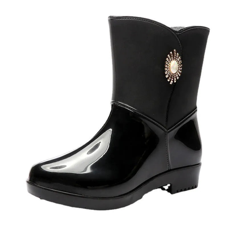 Women's purple PVC rain boots with a middle tube height and non-slip sole on a wet surface.