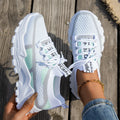 Women's Flyknit mesh sneakers in grey and white, showcasing the breathable upper and flat rubber sole.