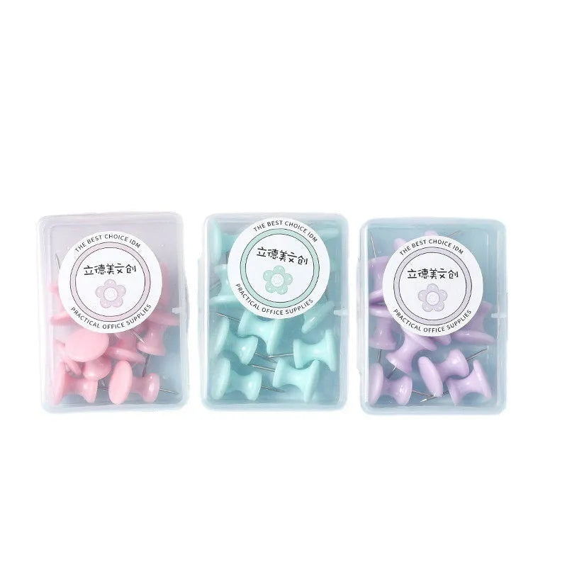 Box of plastic push pins in mint green, pink, and lavender colours, showing large and small thumbtacks for bulletin boards.