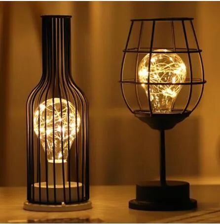Minimalist hollow iron table lamp in a red wine bottle style with warm white LED light.