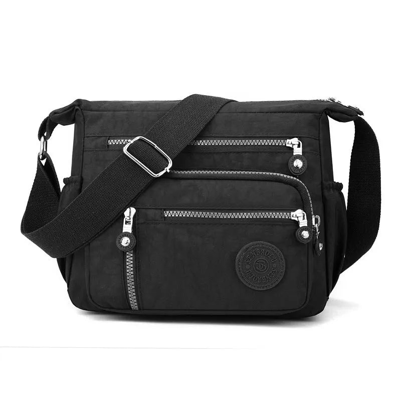 Nylon messenger bag in dark blue with single shoulder strap and soft square design, showing lining cloth interior.