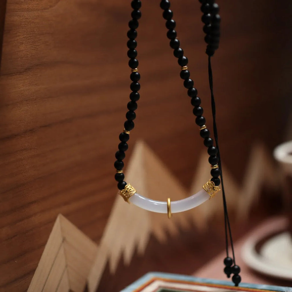 Chinese style U-shaped frosted black agate and white chalcedony necklace on beaded silver chain.