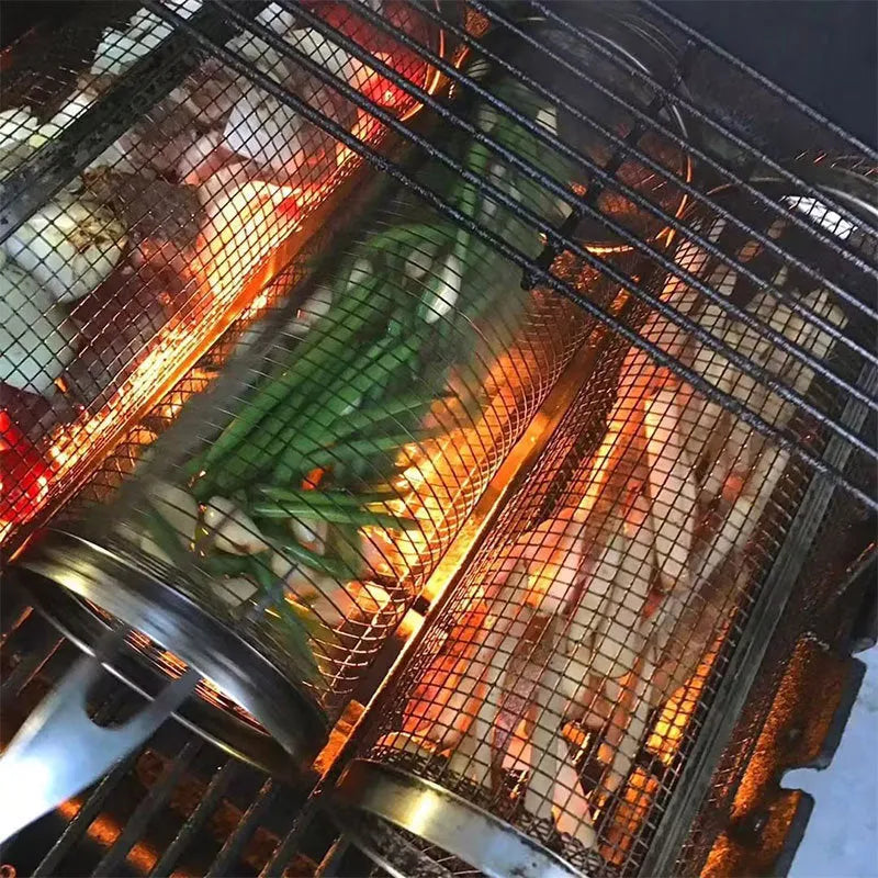 Stainless steel cylindrical rolling grill basket for BBQ with wire mesh, shown with vegetables inside.