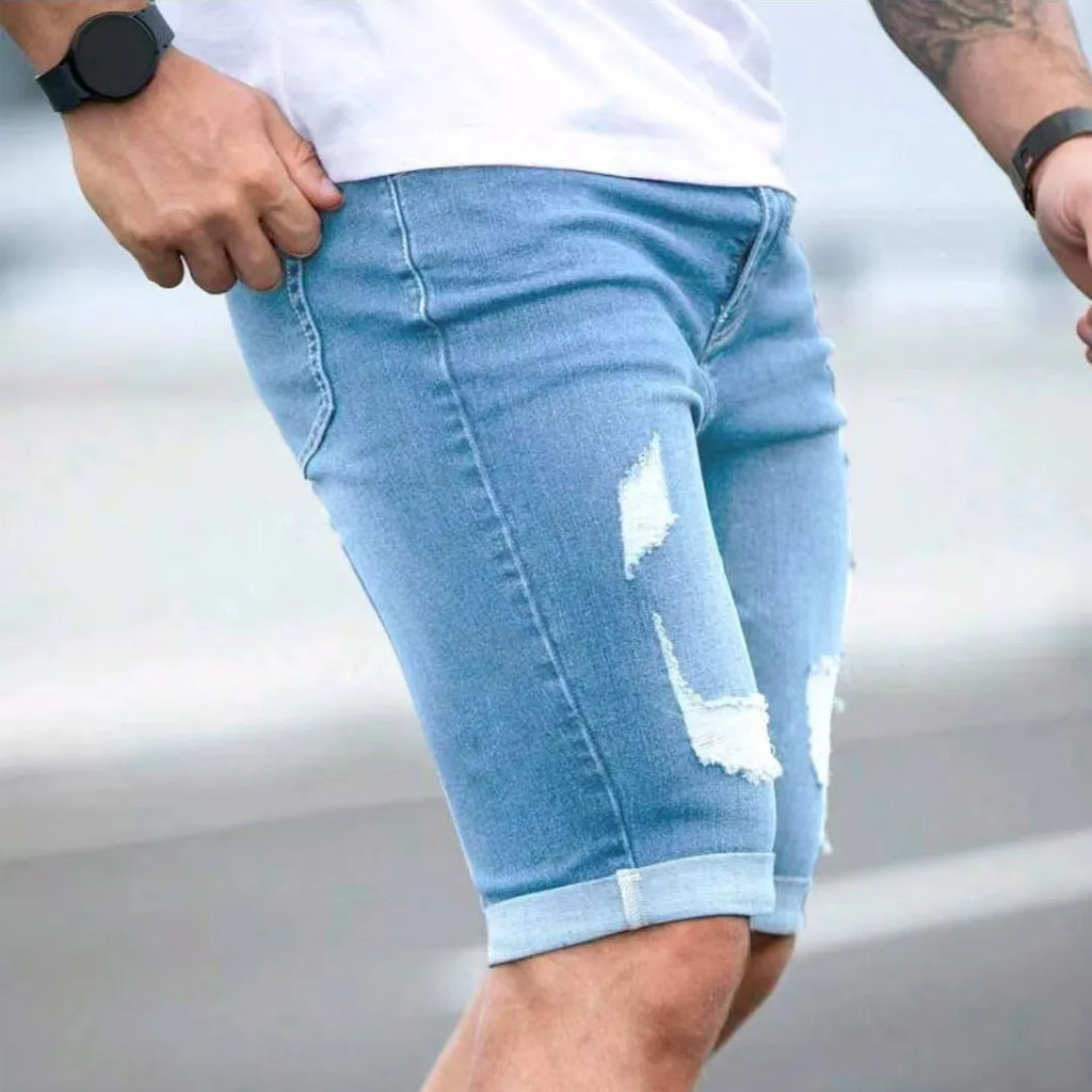 Sky blue men's denim shorts with manual distressing and multi-hole detailing on straight-leg cut