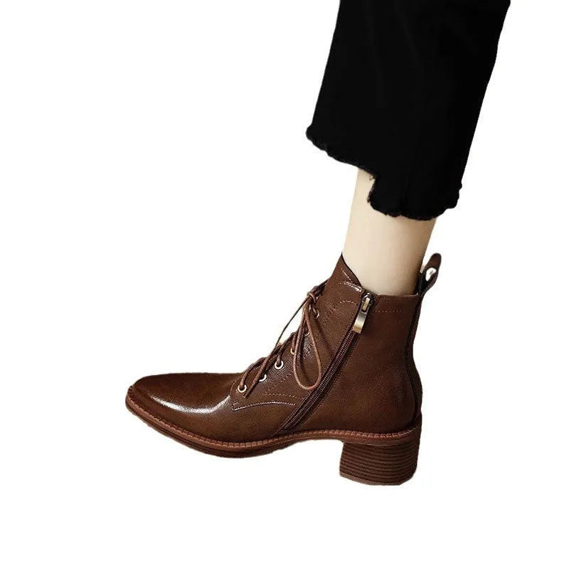 Women's black pointed-toe ankle boots with a short shaft and a low heel on a plain background.