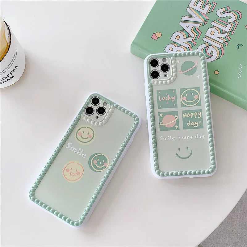 Green TPU iPhone case with geometric smiley face and polka dot frame designs on a table