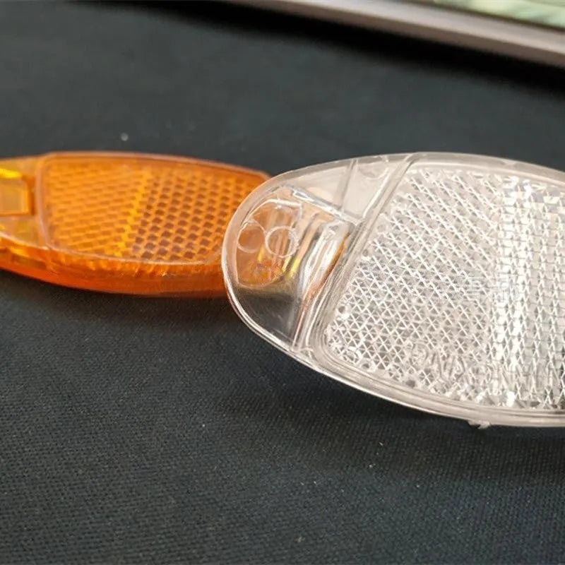 Bicycle reflector spoke decoration in white or yellow, measuring 7.2cm by 3.5cm for night-time cycling safety