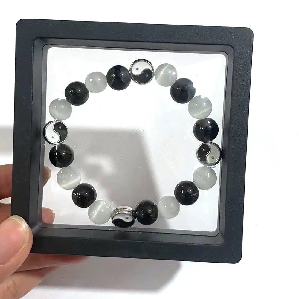 Close-up of a 10mm natural opal and black agate beaded bracelet in a Tai Chi style.