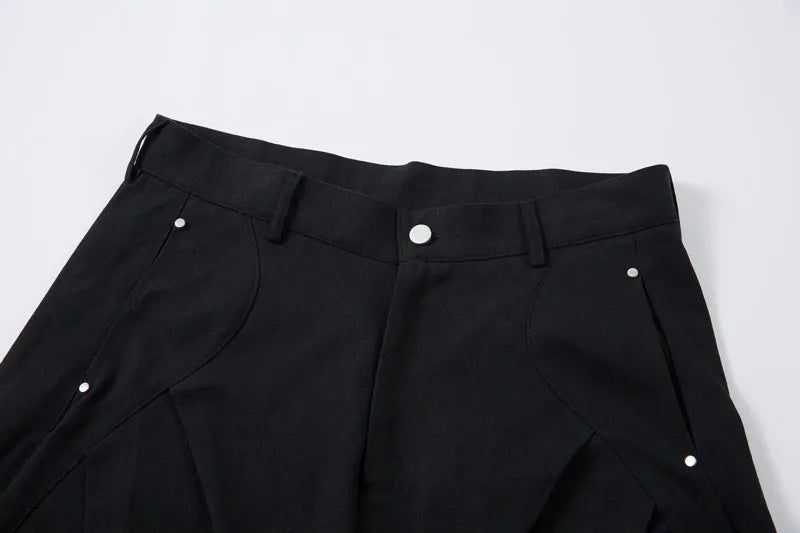 Men's black pleated machete casual trousers with a loose wide-leg fit on a neutral background.