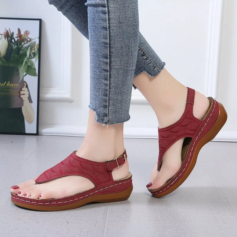 Women's casual wedge heel flip flop sandals with an adjustable buckle strap on the back, shown in a solid colour.
