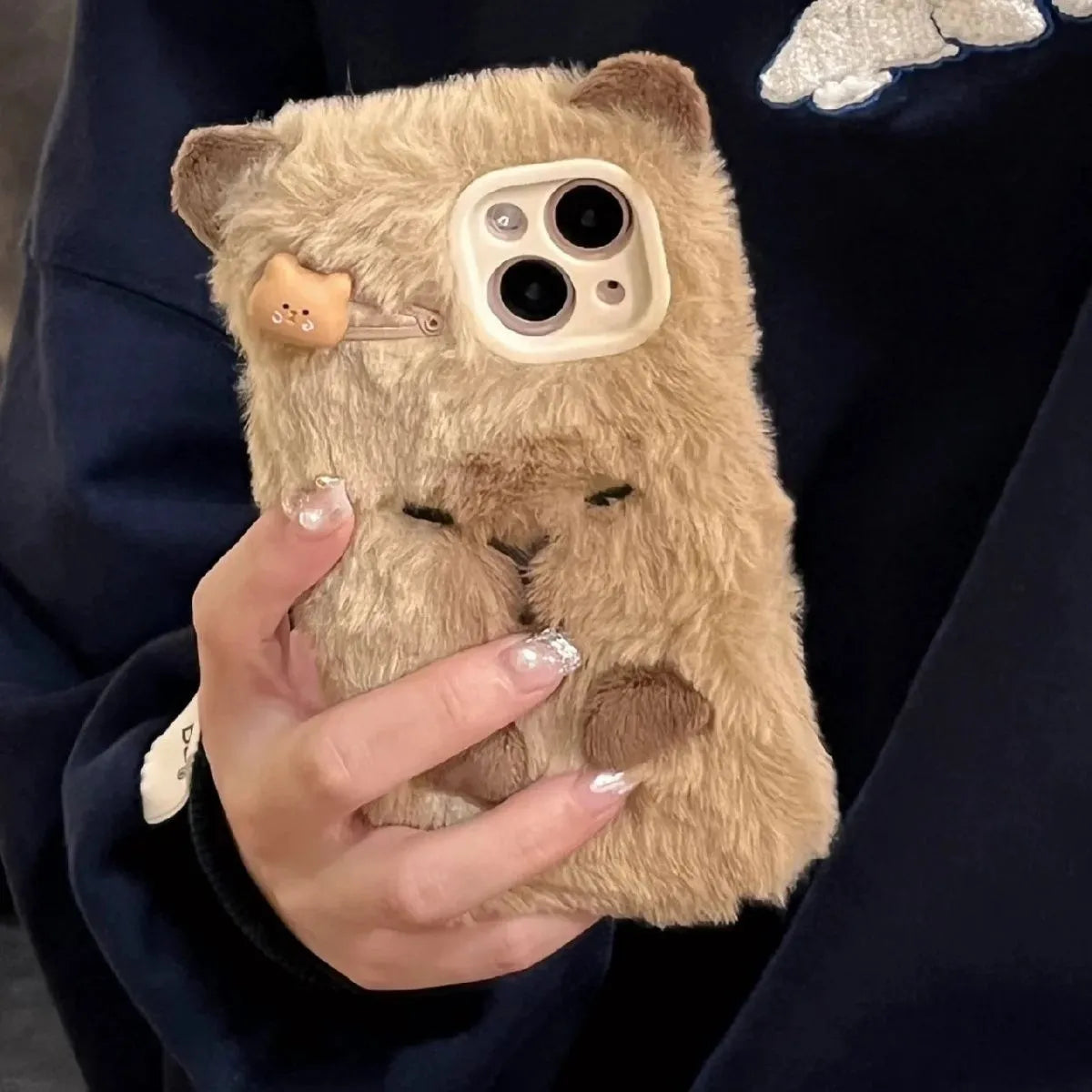 Brown flannel Capabala phone case with plush furry cartoon design for iPhone models