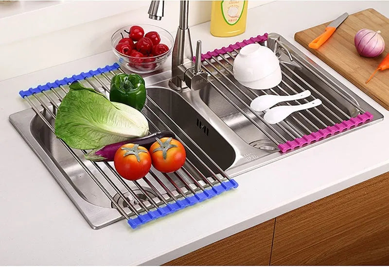 Folding stainless steel dish drainer rack in blue, shown over a kitchen sink