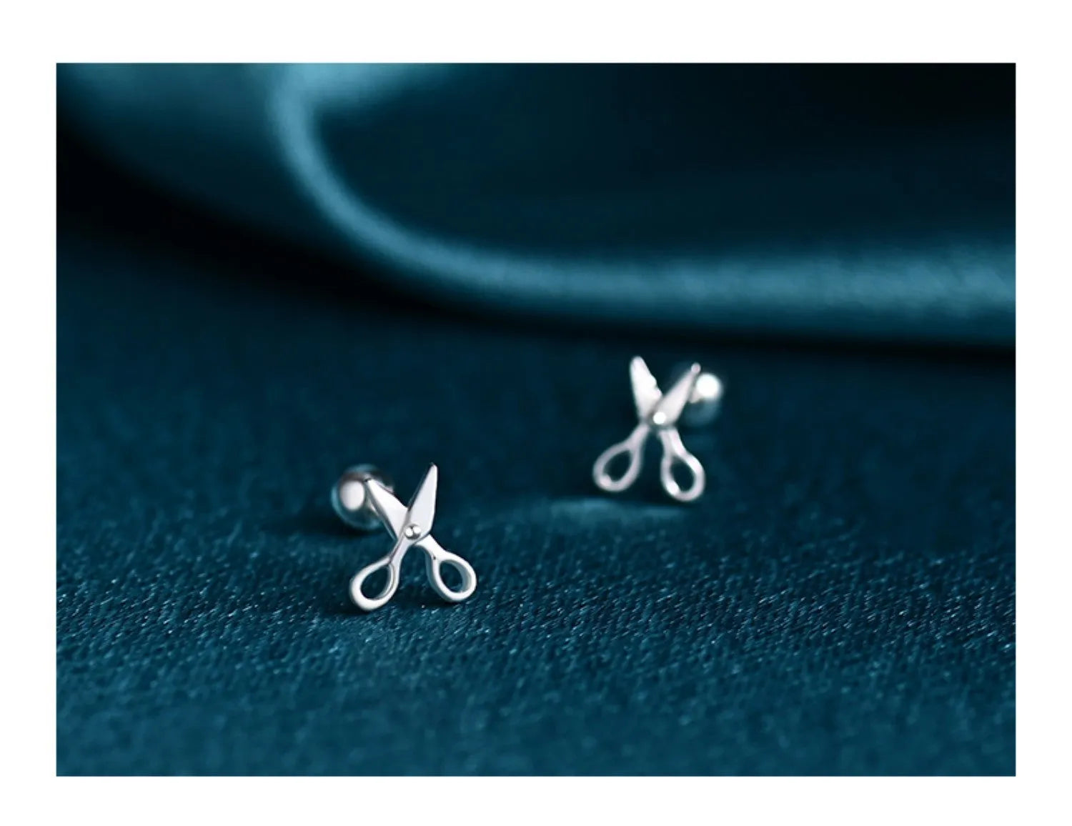 A pair of S999 pure silver earrings with screw-style closure shaped like miniature scissors.