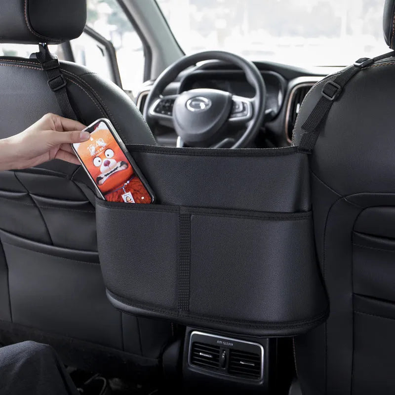 Black leather car seat storage bag with carbon fibre pattern, 38cm long, placed in middle of car seat