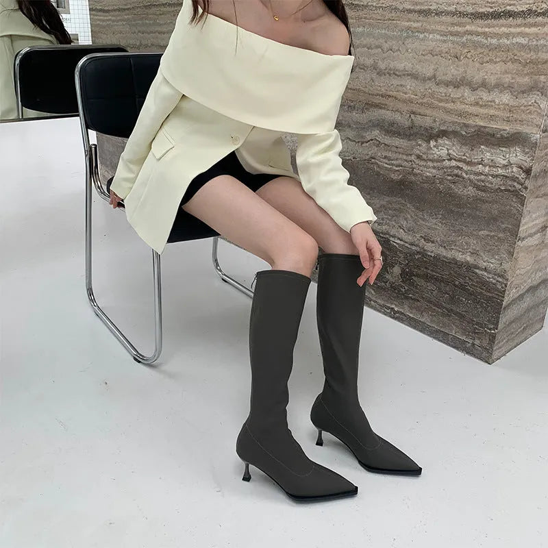 Women's black below-the-knee boots with pointed toe, stiletto heel, and back zipper