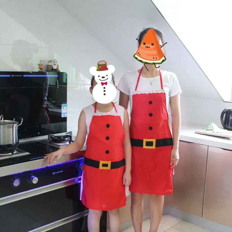Red Christmas apron for adults and children on a hanger, showing adjustable neck and waist straps.