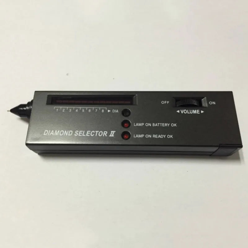 Black handheld diamond thermal conductivity tester with metal probe on a grey background.