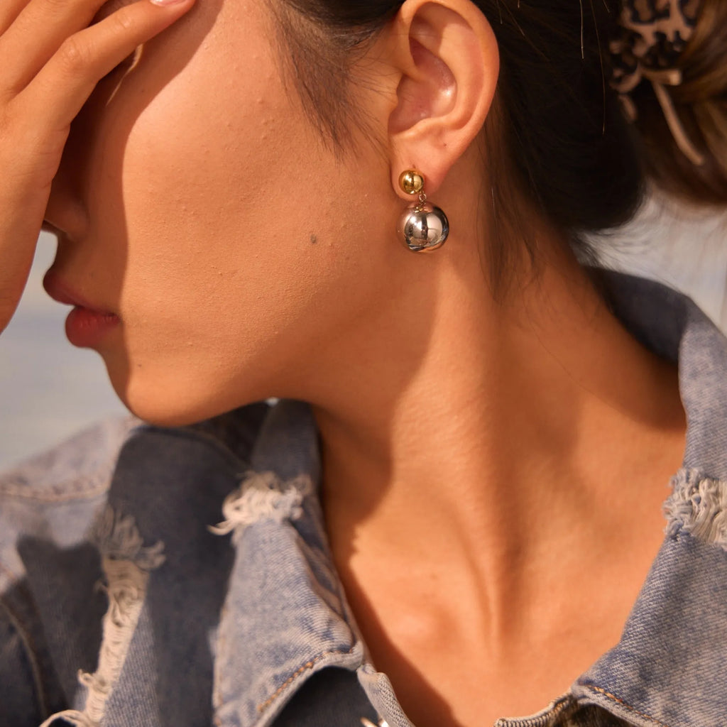 A pair of women's stud earrings with colour-blocked round geometric beads on stainless steel posts.