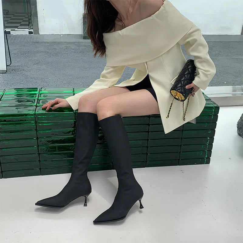 Women's black below-the-knee boots with pointed toe, stiletto heel, and back zipper