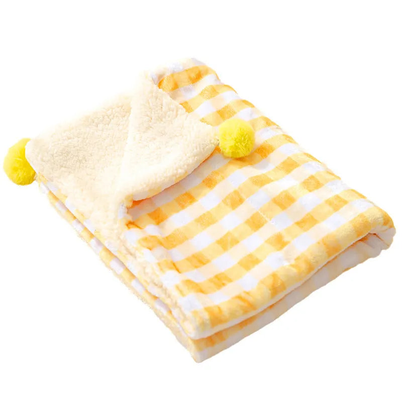 Blue coral fleece pet blanket for dog or cat on a wooden floor.