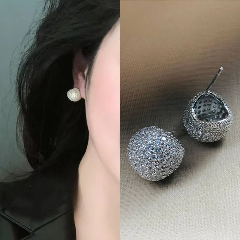 Drop-shaped geometric ear clips with full diamond setting and sphere elements in gold and white finishes