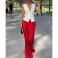 Beige women's sleeveless deep V-neck top and high-waist wide-leg trousers two-piece set on a hanger.