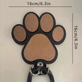 Black wooden wall hook shaped like a paw print for hanging coats and keys