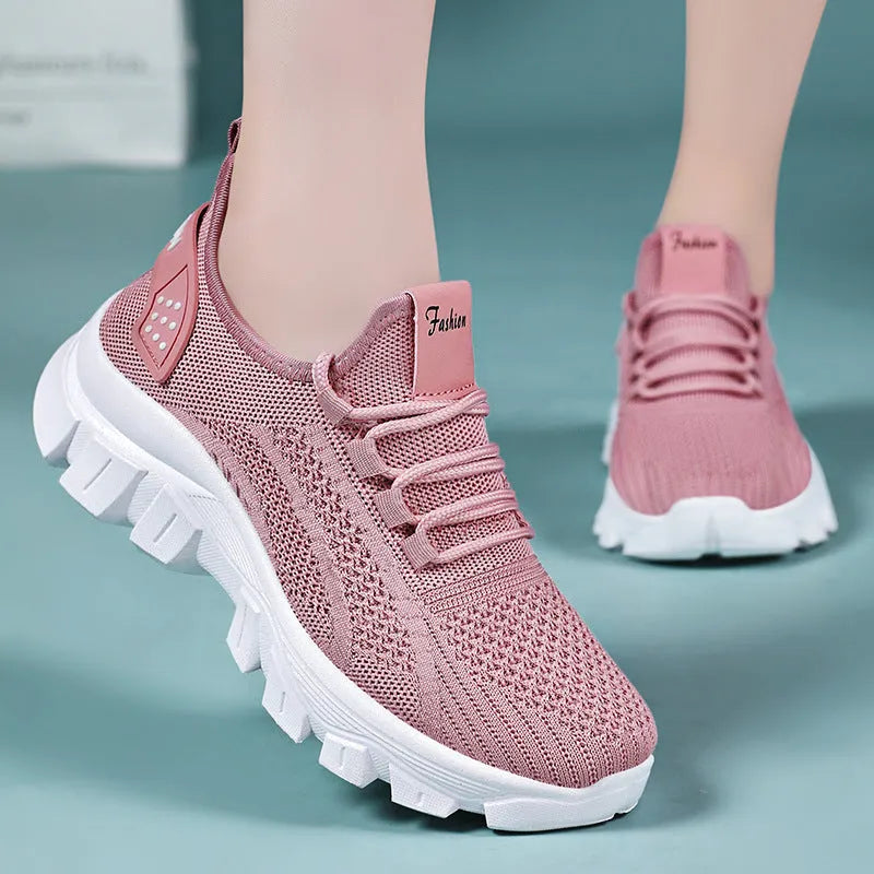 Women's Flyknit sneakers in beige with flat heel, round toe, and lace-up front, showing breathable upper and PVC sole